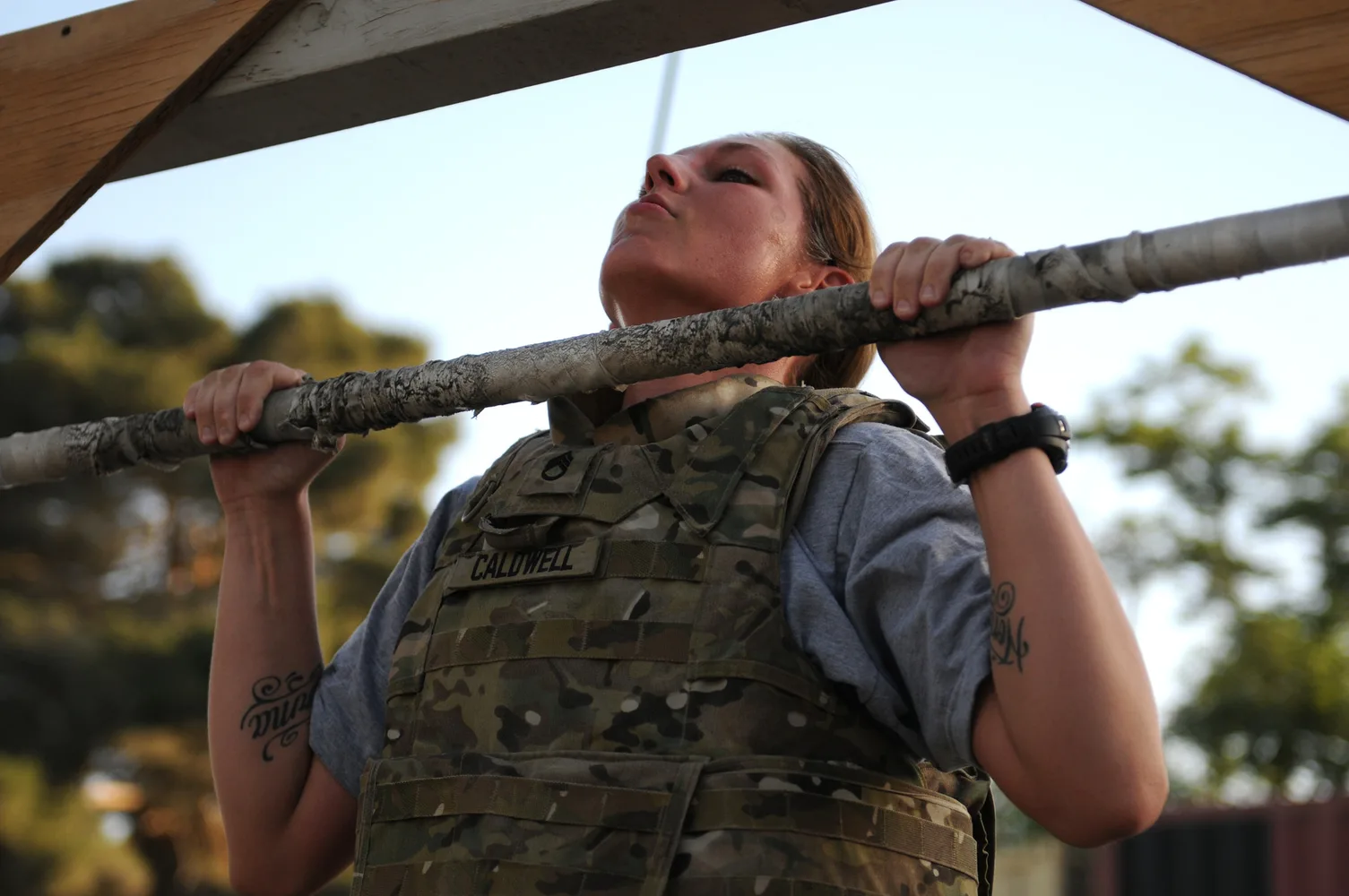 Атлет выполняет подтягивание с дополнительным весом