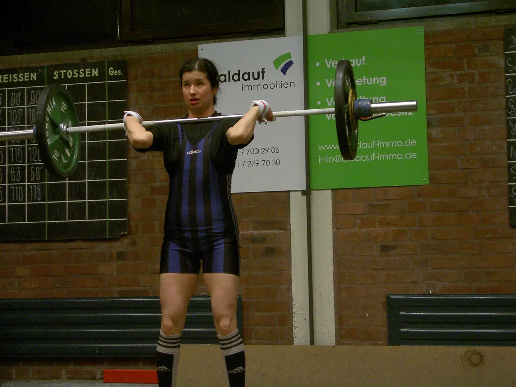 Тяжелоатлет завершает толчок на соревновательном помосте